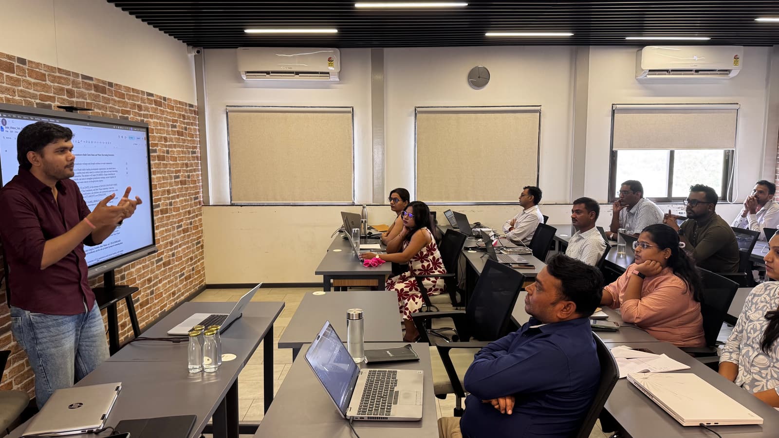 A QriusAI facilitator leading an AI capacity-building session with nonprofit professionals around a shared screen.
