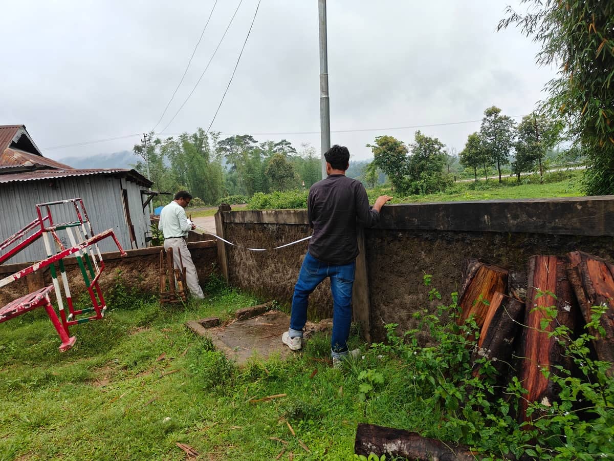 Two field team members measuring the school boundary wall with a tape at Seng Khasi School, Ri-Bhoi District, Meghalaya