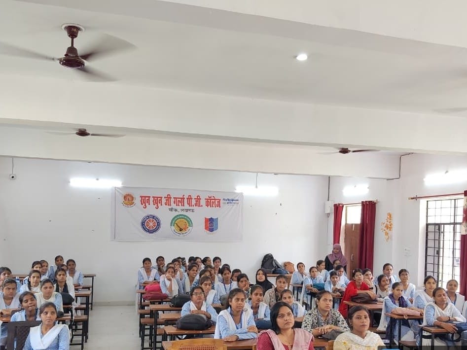 Students in blue checked uniforms seated at desks facing the front at Khun Khun Ji Girls Degree College, Lucknow