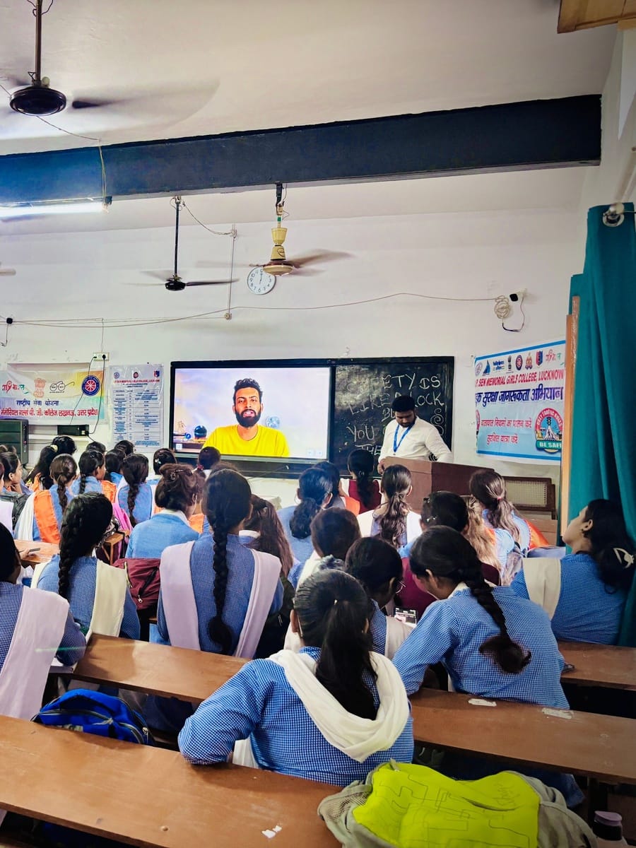 Students in blue uniforms watching a speaker on a large screen at A.P. Sen Memorial Girls College, Lucknow
